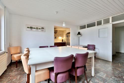 une salle à manger avec une table blanche et des chaises violettes dans l'établissement Gîte Les Sabots d 'Hélène, à Cruzilles-lès-Mépillat