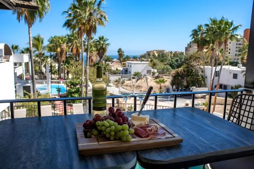 a plate of food on a table with a bottle of wine at Apartment near the beach with terrace #10 in Cabo San Lucas