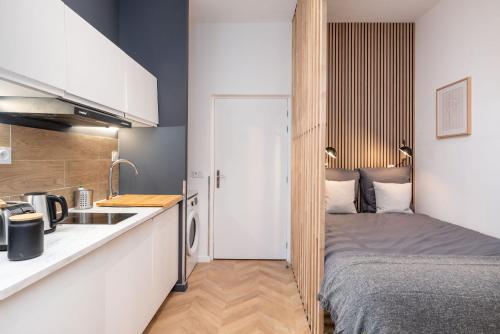 a small apartment with a bed and a kitchen at L'héritage & SPA in Lyon