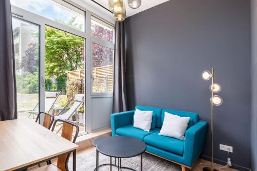 un salon avec un canapé bleu et une table dans l'établissement L'héritage & SPA, à Lyon