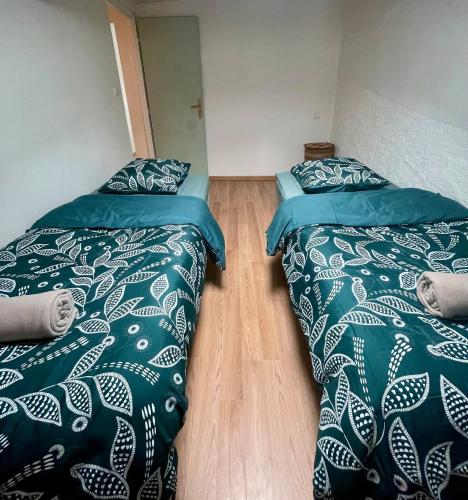 deux lits côte à côte dans une pièce dans l'établissement Charmante maison de village, à Pennautier