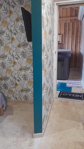 a hallway of a room with a wall with flowers at Love-Room Spa de la TRUFFIERE in Bertric-Burée