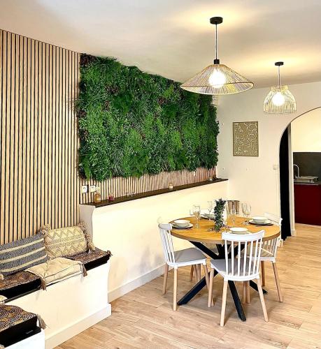 une salle à manger avec une table et un mur vert dans l'établissement Charmante maison de village, à Pennautier
