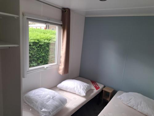 une petite chambre avec deux lits et une fenêtre dans l'établissement D&S Cotttage, aux Mathes