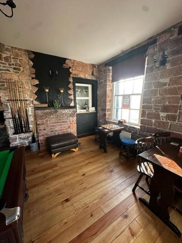 a room with a brick wall and tables and chairs at Ecclefechan Hotel in Ecclefechan