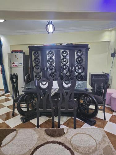 a black cabinet with chairs around it in a living room at Lovely two bedrooms apartment in Asyut city in Asyut