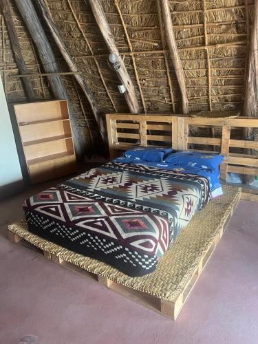 a bedroom with a bed in a thatched room at Hostería Uksha Wasi in Pujilí
