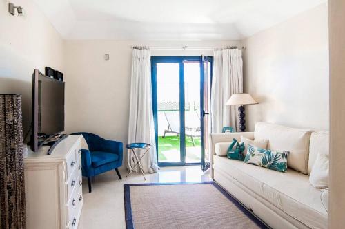 ソトグランデにあるPolo Royale Waterfront Luxury Apt - 3 terraces and poolのリビングルーム(白いソファ、テレビ付)