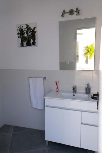 a white bathroom with a sink and a mirror at JVG VILLAS - Villa Giulia in Güimar