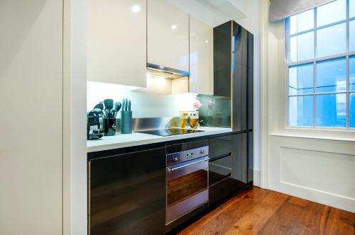 a kitchen with a sink and a stove at Welcome London Mayfair in London