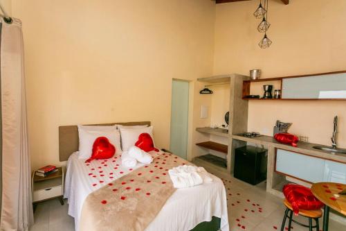 a bedroom with a bed with red pillows on it at Refúgio das Serras in Cunha