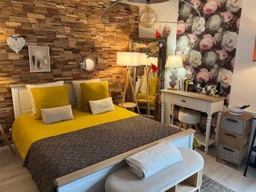 a bedroom with a bed and a table and a mirror at Petit cocon proche de Stanislas in Nancy
