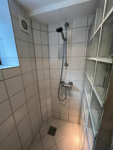 a bathroom with a shower with a shower head at Centralt værelse med bad og køkken in Herning