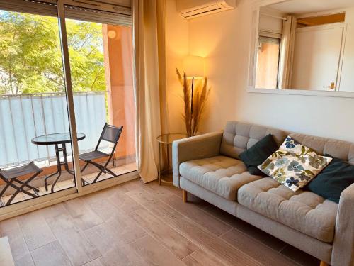 un salon avec un canapé et une table dans l'établissement Claelle Appartment - 200m beach, à Mandelieu-la-Napoule