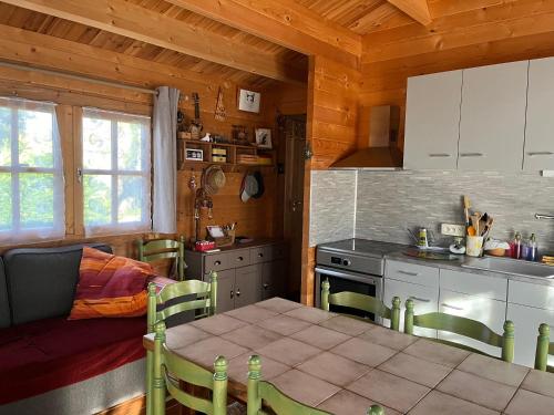 une cuisine avec une table et une cuisine avec une cuisinière dans l'établissement Le chalet de Kiki, au Le Verdon-sur-Mer