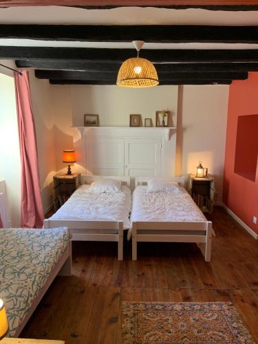 une chambre avec deux lits et deux tables de nuit dans l'établissement Clairefontaine, à Grigne