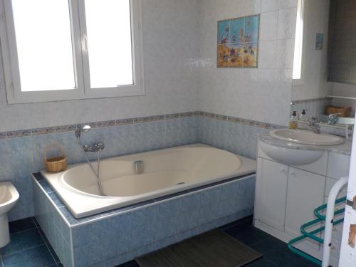 une salle de bain avec une baignoire et un lavabo dans l'établissement Villa climatisée de l'Etang de THAU avec piscine, à Sète
