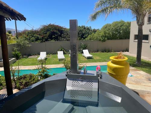 a table with a laptop on it next to a pool at Bird's View Guest Accommodation in Hermanus