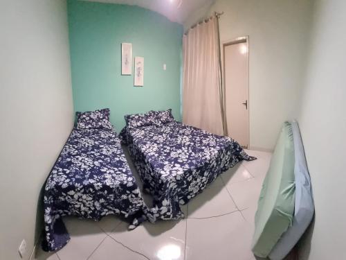 una camera da letto con due letti e una parete blu di Apartamento Residencial Angélica em Guarapari a 150m do mar a Guarapari