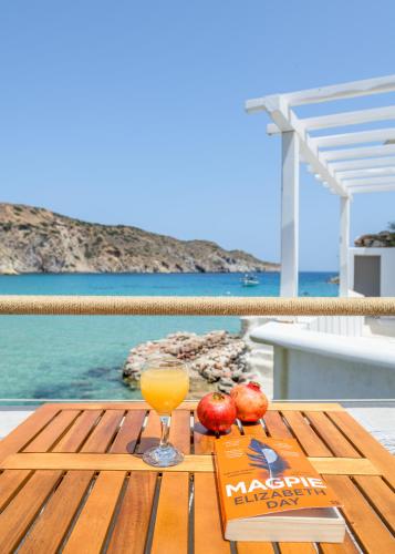 a table with a glass of orange juice and apples on it at Giasemi Boathouse in Firopótamos