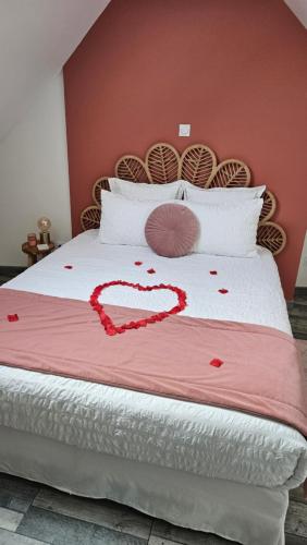 un lit avec un cœur en confetti rouge dans l'établissement Mon doux paradis, à Saint-Germain-la-Poterie