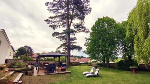a gazebo in a yard with a tree at Chez Martine et Philippe en Velay in Saint-Didier-en-Velay
