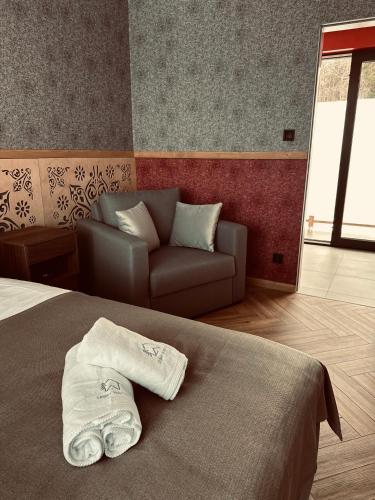 a bedroom with a bed and a couch in it at Leśny Wierch luxury spa villas in Bukowina Tatrzańska