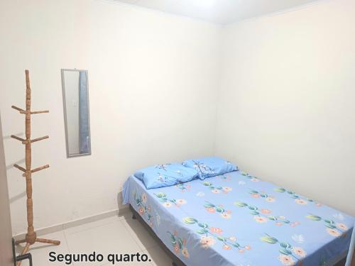 a bedroom with a bed with a blue comforter at Casa no centro de Japaratinga in Japaratinga