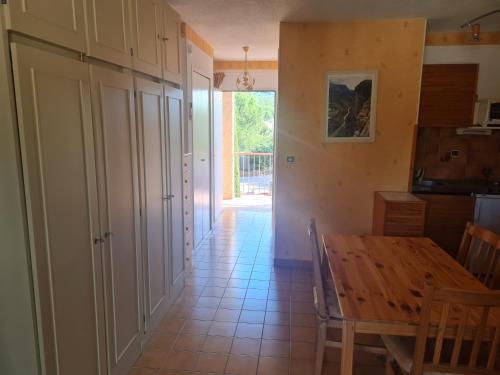 une salle à manger avec une table en bois et un couloir dans l'établissement la petit cure, à Gréoux-les-Bains