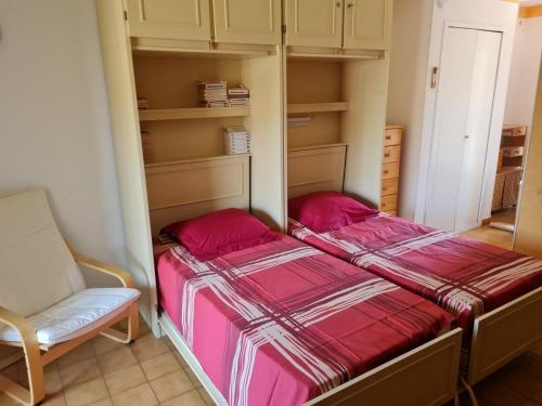 une petite chambre avec un lit et une chaise dans l'établissement la petit cure, à Gréoux-les-Bains