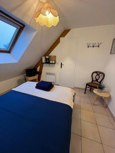 - une chambre mansardée avec un lit bleu dans l'établissement Les gîtes du Mesnil chambre standard, à Équemauville