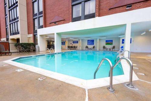 a large pool in a building with chairs and tables at Heritage Inn & Suites The Woodlands, Trademark by Wyndham in The Woodlands