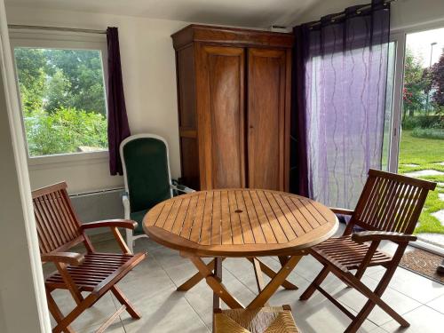 - une table en bois et 2 chaises dans une chambre dans l'établissement Un studio indépendant avec jardin, à Talmont-Saint-Hilaire