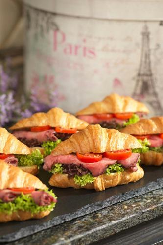 a bunch of sandwiches sitting on a table at Renaissance Vienna Schönbrunn Hotel in Vienna