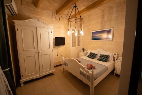 Un dormitorio con una cama blanca y una lámpara de araña. en House Of Sliema - 4BR Traditional Townhouse, en Sliema