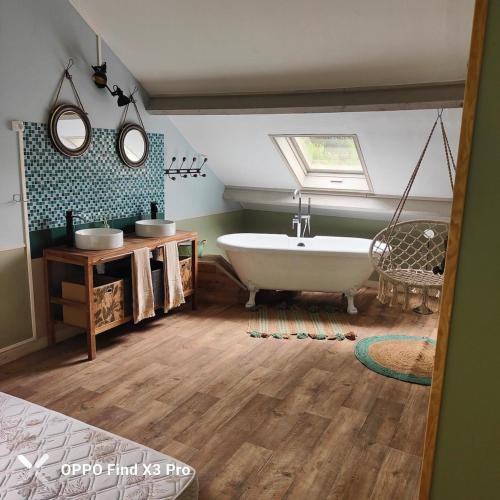 une salle de bain avec une baignoire et un lavabo dans l'établissement La maison au Vert, à Auxerre