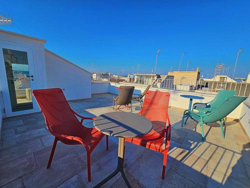 a group of chairs and a table on a patio at RomAntica - Sunset & Terrace in Polignano a Mare