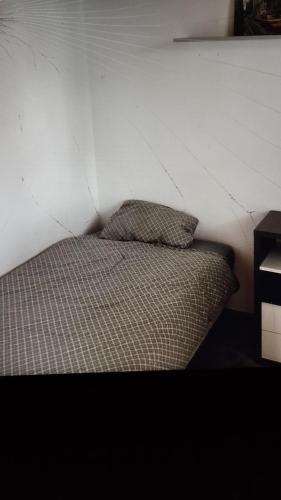 Ce lit se trouve dans un dortoir doté d'un mur blanc. dans l'établissement Nartelle 26, à Sainte-Maxime