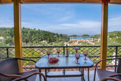 a table with glasses of wine on a balcony at Dream view apartments in Lákka