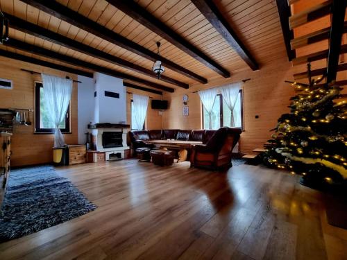a living room with a christmas tree and a couch at Czirják Kulcsosház in Bucsin