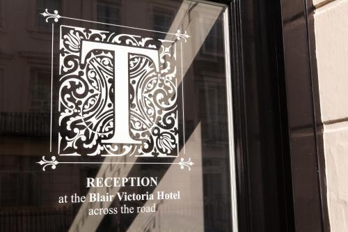 a sign in the window of a door with the letter i at The Tudor Inn Hotel in London