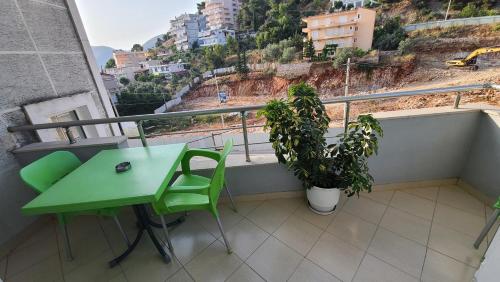 a green table and a chair on a balcony at Luxury Room's by Lika in Sarandë