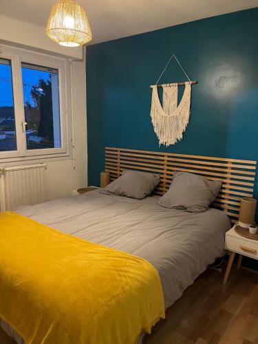 une chambre avec un grand lit avec une couverture jaune dans l'établissement Apartment T3, à Billère
