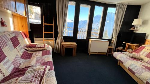 a hotel room with two beds and large windows at Résidence Les Ruches - maeva Home - Studio 4 personnes - Sélection MAE-5761 in Avoriaz
