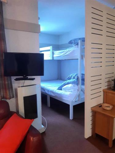 - une chambre avec des lits superposés, une télévision et des lits superposés dans l'établissement Résidence Plagne Lauze - maeva Home - Appartement 2 pièces 5 personnes - Sélection MAE-2091, à Mâcot La Plagne
