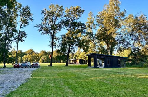a small cabin with cars parked in a park at La Casa del Bosque in Neltume
