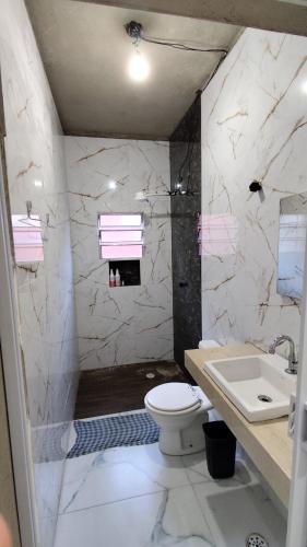 a bathroom with a toilet and a sink at Descanso - Casa de Praia in Mongaguá