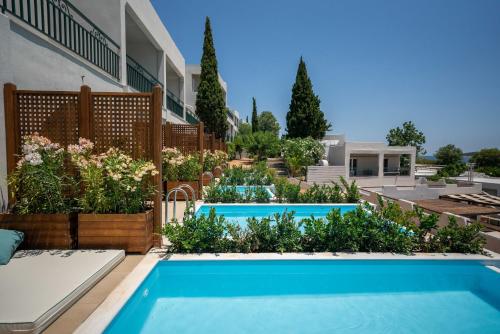 a backyard with a swimming pool and some plants at Dolce by Wyndham Athens Attica Riviera in Vravrona