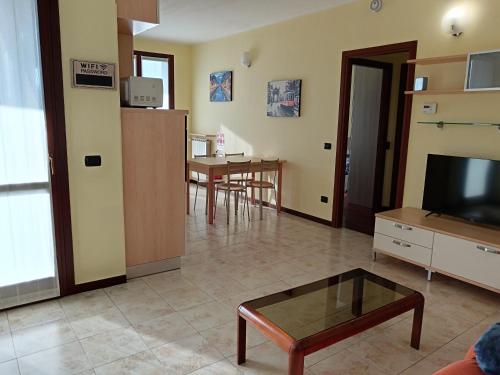 a living room with a television and a table at Appartamento dei Salici in Gallarate