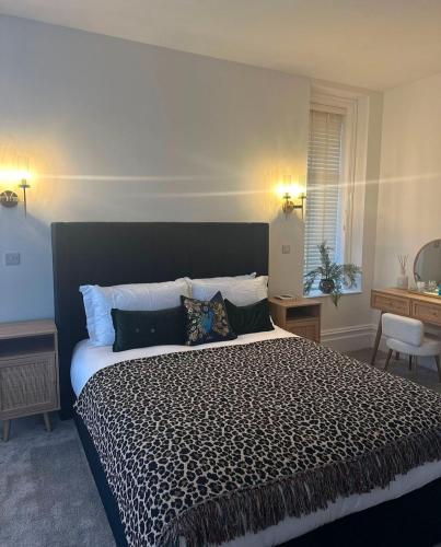a bedroom with a large bed with a black and white comforter at The Magnolia in Rhôs-on-Sea